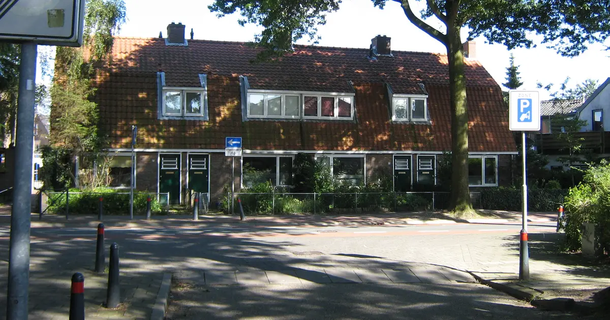 Rij eengezinswoningen met dakkapellen en een pannendak in een Nederlandse straat